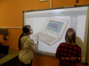 Realizacja projektu - uczniowie korzystający ze sprzętu. Uczennice przy tablicy interaktywnej